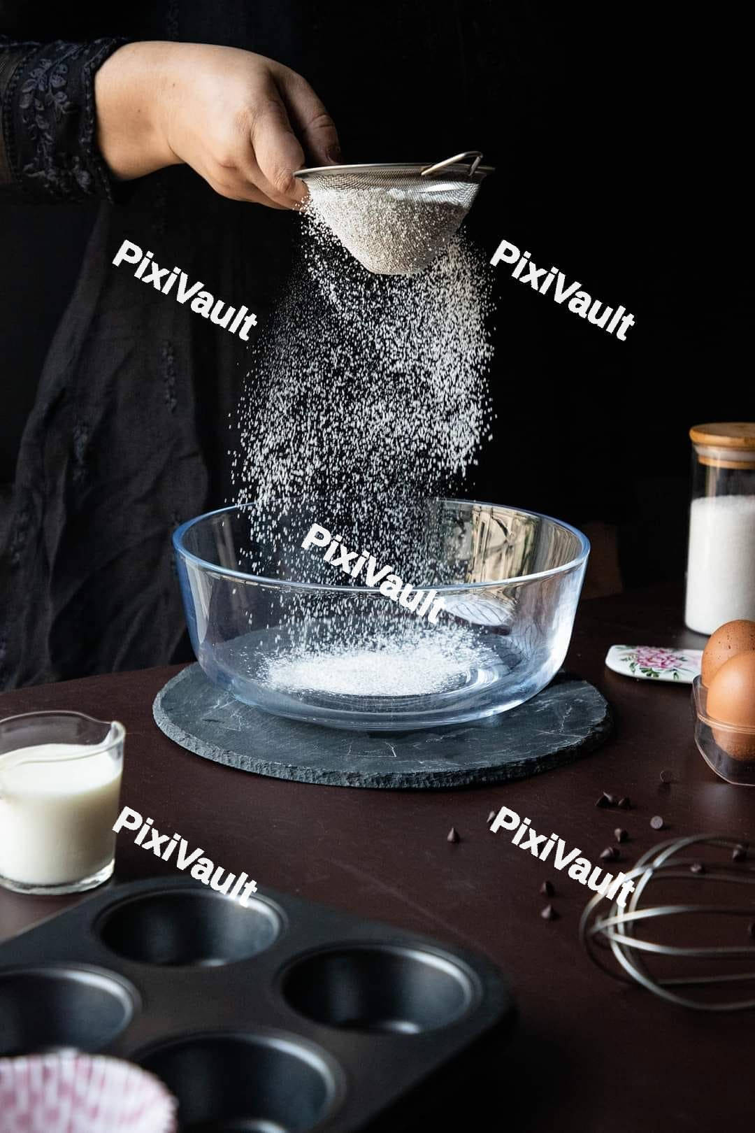 Hand pouring sugar into a bowl